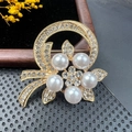 Detailed close-up of a vintage golden brooch with white pearls and sparkling crystals - BZ023 Ribbon Ring Flower