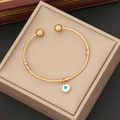Golden stainless steel open bangle with blue evil eye enamel charm in a gift box - White