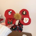 Close-up of red velvet Christmas bow hair tie with Santa Claus and resin charms - Red Bow Hair Tie with Yellow Fur Ball