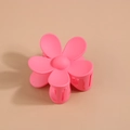 Vue détaillée de la pince à cheveux fleur rose mate avec ressort sur fond beige clair - Rose rouge