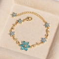 Detailansicht eines luxuriösen blauen Blumenarmbands mit Zirkonia in einer Samtbox - Blume Blauer Zirkon Gold