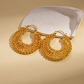 Dettaglio di orecchini a cerchio intrecciati placcati in oro 18k su base in pietra naturale - Oro