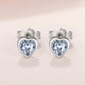 Macro shot of light blue heart-shaped crystal earrings with polished silver metal base - Light Blue