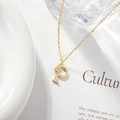Detailed close-up of golden letter P pendant with zircon flower on a refined O-chain - Letter P