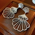 Close-up of silver fan-shaped earrings with sparkling cubic zirconia on wood background - Silver Needle - Silver Fan-shaped Ear Pendant / Silver