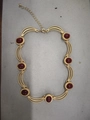 Vintage style gold necklace featuring burgundy oval gemstones and curved metal links - Red Gemstone Necklace