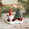Miniature resin Christmas gnome with green tree and golden bow on snowy base - Santa with Christmas Tree