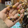 Close-up of vintage ethnic bracelet with multicolored agate beads and metal bell pendant - Style B: Ox Bone Vajra Pestle Bracelet