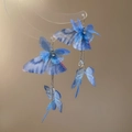 Detalle de pendientes de mariposa azul con flecos largos y cuentas de gota de agua - Estilo de Gancho / Azul