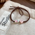 Detail of pink plaid cat and shell resin charms on coffee brown elastic hair ties - Pink Cat