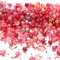 Mix of red and pink DIY glass beads including star and fish shapes for jewelry making - Carmine
