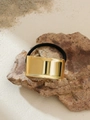Close-up of black elastic hair tie with gold rectangular metal bead on natural stone - Golden Smooth Rectangular