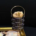 Detail of luxury rhinestone bucket bag with gold hollow frame and pearl drawstring - Black