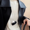 Collar minimalista con colgante de corazón negro y plata mostrado en una modelo - Estilo de Corazón Cosido (50#)