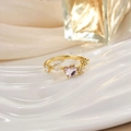 Macro detail of gold ring with pink heart stone and leaf-shaped crystals on white display - Pink Heart Leaf Decor (JZ0152E)