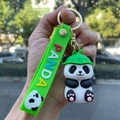 Close-up of a silicone panda keychain with a green hat and colorful PANDA strap - Panda Gen 4 - Style 02