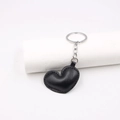 Minimalist black PU leather heart-shaped keychain with silver metal ring on white background - Black