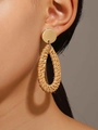 Close-up of bohemian water drop woven rattan earrings on a model's ear - Golden Brown Teardrop Rattan Style (0022)