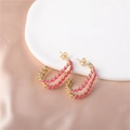 Close-up of gold twisted hoop earrings with rose pink enamel finish on champagne silk fabric - Gold (E00288-13)
