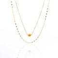 Detail of double-layer gold necklace featuring orange natural stone on white background - Red Aventurine