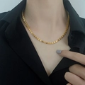 Close-up of elegant 18k gold cuban link necklace texture on black shirt model - H647 Phoenix Tail Gold Necklace (Heart Tag)