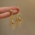 18k gold plated multi-layer hollow teardrop earrings held by hand for scale - Multi-Layer Teardrop Hollow (48#) / Gold