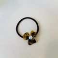 Macro detail of elastic hair tie with amber leopard petals and pearl centerpiece - Tortoise