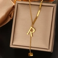 Detail macro-opname van gouden letter R-hanger en vierkante bedel aan de halsketting - Letter R (WY006-R)