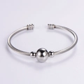 Brazalete ajustable de cable de acero inoxidable plateado con una cuenta central pulida - Color Acero