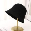 Women's black knitted bucket hat with a breathable design on a gold display stand - Black