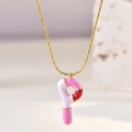 Detail of golden necklace with pink and white enamel letter P pendant on stone - Letter P