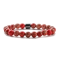 Close-up of 8mm red jasper beads with unique patterns and a black cylindrical spacer bead - Red Imperial Jasper