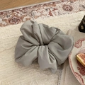 Close-up of light gray puffy fabric scrunchie on cozy vintage plush background - Gray