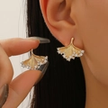 Elegant gold ginkgo leaf stud earrings with sparkling diamonds shown on ear and hand - Gold Zirconia Ginkgo Leaf Stud Earrings (11503)