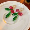 Macro shot of elegant pink and green teardrop glass earrings with golden metal clasps - Hoop-Gold-Red-Green