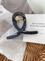 Elegant black twist hair claw clip with gold spring detail on white paper background - Linen Grey