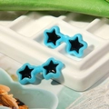 Detail of blue resin star-shaped sunglasses for plush dolls on white grid tray - Blue