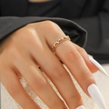 Close-up of heart-shaped gold ring with zircon stones on a model's hand - Gold Hollow Heart Pavé