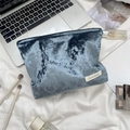 Macro detail of dark blue velvet cosmetic bag with Sozakka brand tag on white fabric - Dark Green