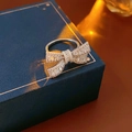 Macro shot of silver bow ring with shimmering cubic zirconia on a blue jewelry box - Silver