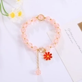 Detail showing handmade pink crystal beads and red flower pendant bracelet with gold accents - Pale Pink
