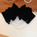 Detail of a black velvet bow hair clip with triple-layered pearl tassels on wood background - Black Velvet Bow Spring Clip