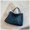 Detalle de un bolso tote grande de cuero sintético azul marino sobre sábana blanca - Azul
