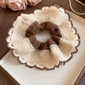 Close-up of oversized knitted scrunchie with lace trim on a decorative wooden tray - Coffee & Beige Color Block