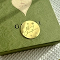 Close-up of a green embossed gift box with a gold Merry Christmas acrylic tag - Merry Christmas Gold Style
