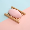 Pink oval handmade soap on a wooden holder with a minimalist dual-color background - 110g Thai Rose Soap
