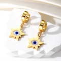 Detail of gold evil eye star earrings on white stone display with silk background - Star Royal Blue Eye