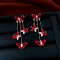 Macro shot of long gold earrings with butterfly design and red stones on black velvet - Gold Red Zirconia Butterfly Tassel Long Stud Earrings