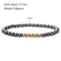 Detail showing 5mm dark grey hematite beads and gold accents on an elastic bracelet - 5mm