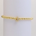Macro detail of gold beaded bracelet featuring a shimmering zircon-paved letter J charm - Letter J